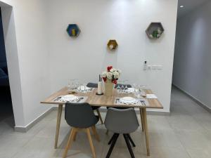 un tavolo di legno con sedie e un vaso di fiori di Confort et tranquilité a Abidjan Altre 10 foto