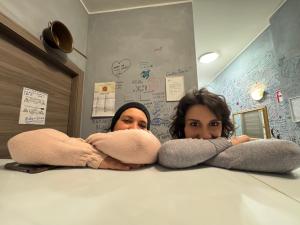 a man and a woman standing behind a counter at Gloria Hostel Milano in Milan