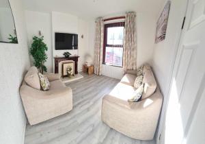 a living room with two couches and a television at Derry City Centre Kelly's Place et in Derry Londonderry