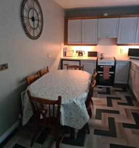 a kitchen with a table with chairs and a clock on the wall at Derry City Centre Kelly's Place et in Derry Londonderry