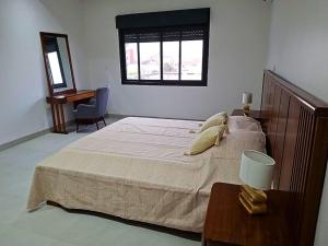 a bedroom with a large bed and a desk at Elegant 3-room apartment in Dakar