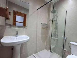 a bathroom with a sink and a glass shower at Elegant 3-room apartment in Dakar +2 photos