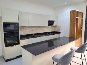 a kitchen with a sink and a stove and two stools at Elegant 3-room apartment in Dakar