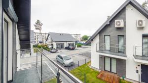 an apartment balcony with a car parked in a parking lot at Dom Horizon Park 3A in Dziwnówek