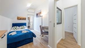 a bedroom with a blue bed and a desk at Dom Horizon Park 3A in Dziwnówek