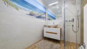 a bathroom with a sink and a shower at Dom Horizon Park 3A in Dziwnówek +7 photos