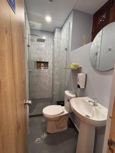 a bathroom with a toilet and a sink and a shower at Hostal Boutique Loto de Belén in Bogotá +37 photos