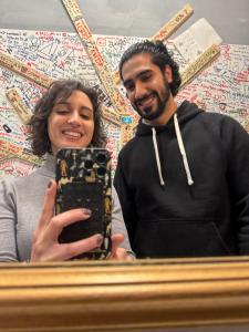 a man and a woman taking a picture in a mirror at Gloria Hostel Milano in Milan