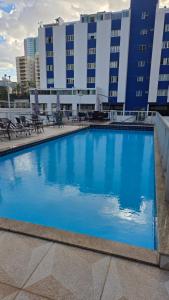 a large blue swimming pool in front of a building at Um lar em Brasília, super aconchegante e com ar condicionado in Brasília