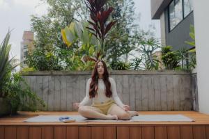 a woman sitting on the floor in a yoga pose at Nomadic Boutique Living and Experience Center in Medellín