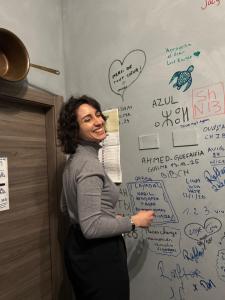 a woman standing in front of a wall with writing on it at Gloria Hostel Milano in Milan +226 photos