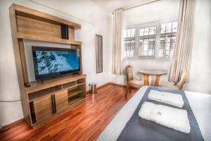 a room with a television and a bed and a table at FRIENDLY AQP in Arequipa