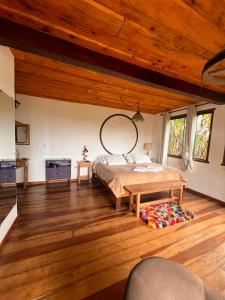 a bedroom with a bed and a wooden floor at Chalé da Mata Lavras Novas in Lavras Novas