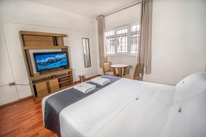 a bedroom with a white bed and a television at FRIENDLY AQP in Arequipa +45 photos