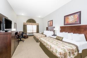 a hotel room with two beds and a flat screen tv at Canalta Olds in Olds +8 photos