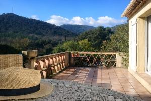 a hat sitting on a balcony with mountains in the background at Maison du vieux chêne in Grimaud