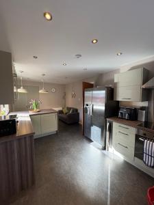 a kitchen with stainless steel appliances and a living room at Arcadia - Kirkwall in Orkney