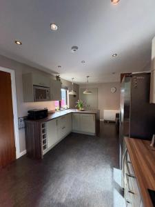 a kitchen with white cabinets and stainless steel appliances at Arcadia - Kirkwall in Orkney +1 photo