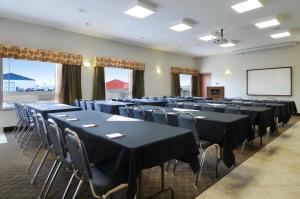a conference room with tables and chairs and a screen at Canalta Olds in Olds