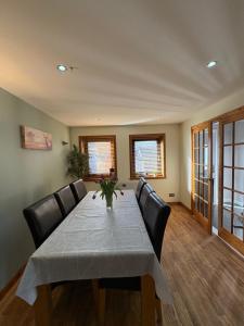 a dining room with a table and leather chairs at Arcadia - Kirkwall in Orkney