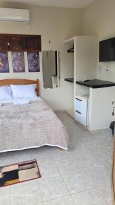 a bedroom with a bed and a small kitchen at Pousada irmãos Calixto in Portalegre