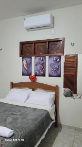 a bedroom with a bed with posters on the wall at Pousada irmãos Calixto in Portalegre