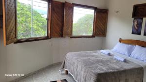 a bedroom with a bed and two windows at Pousada irmãos Calixto in Portalegre +3 photos