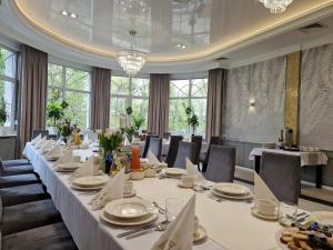 a long dining room with a long table and chairs at Stara Palmiarnia Mimoza in Rybnik