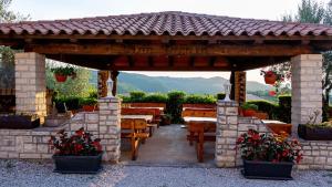 a pavilion with a table and benches and flowers at Vinea Nature in Brkač