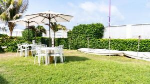 a table and chairs with an umbrella in the grass at Sunshine Boutique Hotel in San Andrés