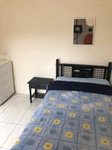 a bedroom with a bed and a dresser in it at Habitación orégano in Santa Elena