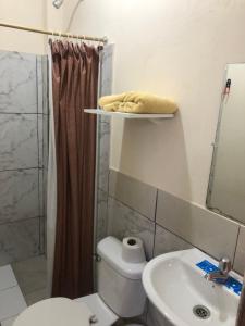 a bathroom with a toilet and a sink and a shower at Habitación orégano in Santa Elena +2 photos