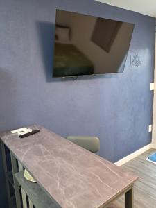 a table with a television on a blue wall at Small's Cozy Rest 9 Efficiency in South Bimini
