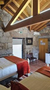 a bedroom with two beds in a stone wall at Quinta Lama de Cima in Fafe +161 photos