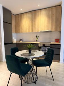a kitchen with a table and chairs in a room at Pipera Garden Apartment in Voluntari