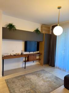 a living room with a desk with two plants on the wall at Pipera Garden Apartment in Voluntari