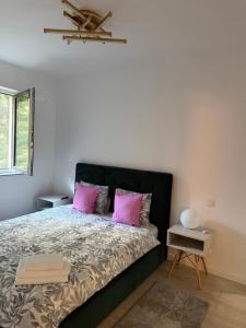 a bedroom with a bed with pink pillows at Pipera Garden Apartment in Voluntari