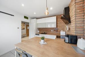 a kitchen with white cabinets and a brick wall at Haban Haus in Bratislava