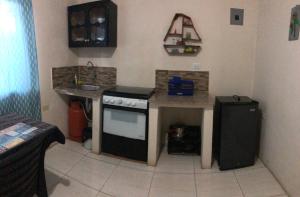 a small kitchen with a stove and a sink at hospedaje Maluli suite girasol in Santa Elena