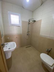a bathroom with a toilet and a sink at Villa blanche sfax in Sfax