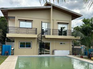 a house with a swimming pool in front of it at Scarlett Near Mount Zion in Bugallon