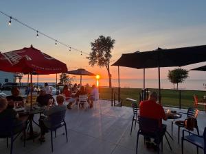 a group of people sitting at tables watching the sunset at The Painted Pelican in Luxemburg