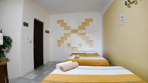 two beds in a small room with at BRISAMAR GUESTHOUSE in Puerto Escondido +83 photos
