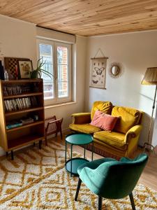 a living room with a couch and a table at Appartements Lambotte in LʼAigle