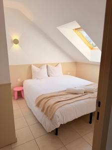 a bedroom with a white bed with a skylight at Au cœur des vignes - Piscine Sauna & Climatisation in Levernois