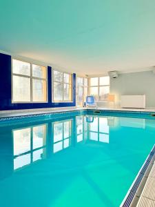 a large swimming pool with blue water at Au cœur des vignes - Piscine Sauna & Climatisation in Levernois