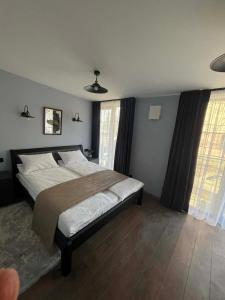 a bedroom with a large bed and two windows at Villa Rinat Boutigue Hotel in Kyiv