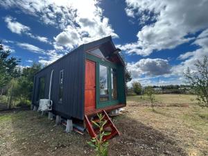 ein kleines Haus steht auf einem Feld in der Unterkunft tiny house DyL in Puerto Montt