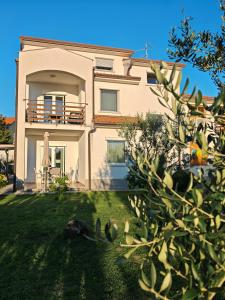 a house with a yard with a tree at Apartma S&M in Koper