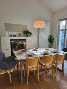 a dining room with a white table and chairs at Ferienhaus an der Allee in Kalkar